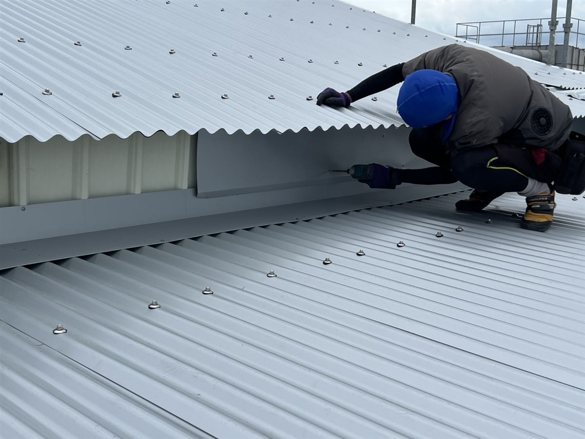 上下の屋根の間にある壁面を板金で覆う作業